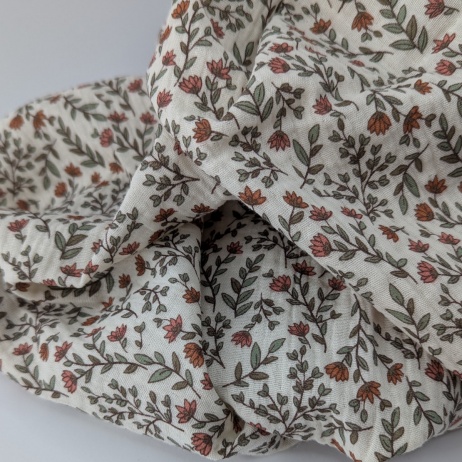 Double gauze 100% cotton, small orange flowers on a beige background