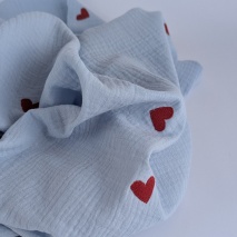 Cotton muslin with embroidered red hearts on a blue background