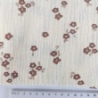 Cotton muslin with brown flowers on a vanilla background