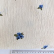 Cotton muslin with embroidered blue fruits on a natural background