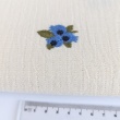 Cotton muslin with embroidered blue fruits on a natural background