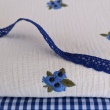 Cotton muslin with embroidered blue fruits on a natural background